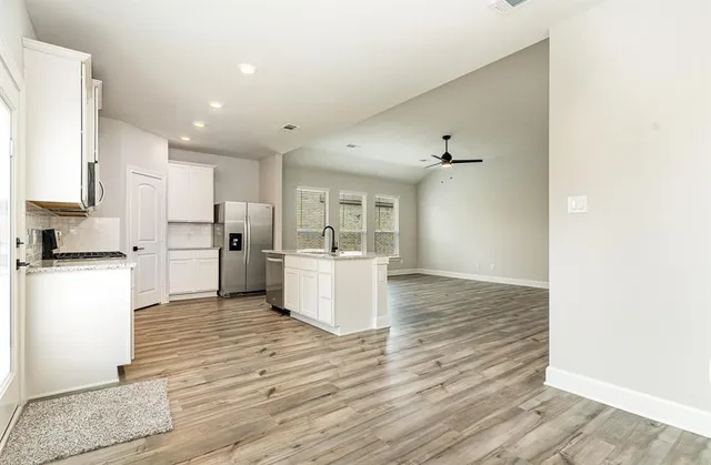 a kitchen with kitchen island a sink appliances and cabinets