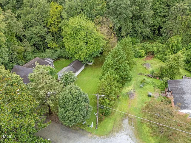an aerial view of residential houses with outdoor space and trees
