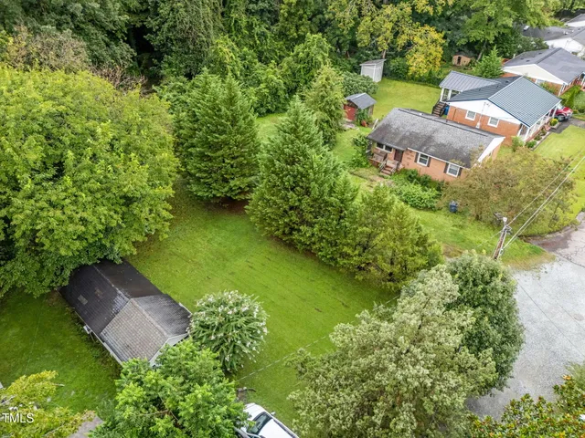 an aerial view of a house with garden space and street view