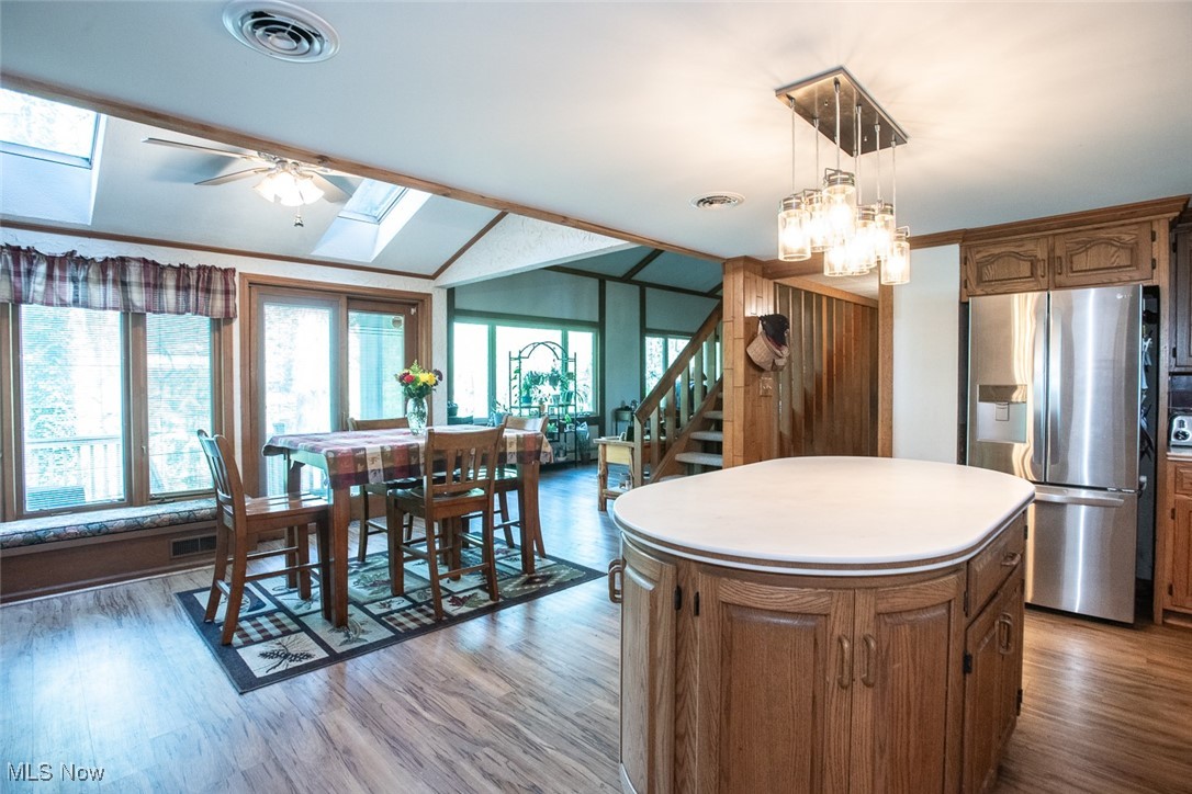 41180 Butternut Ridge Road Elyria, OH 44035 - Photo 23 of 50 Kitchen with stainless steel refrigerator with ice dispenser, a skylight, lofted ceiling, healthy amount of natural light, and a kitchen island