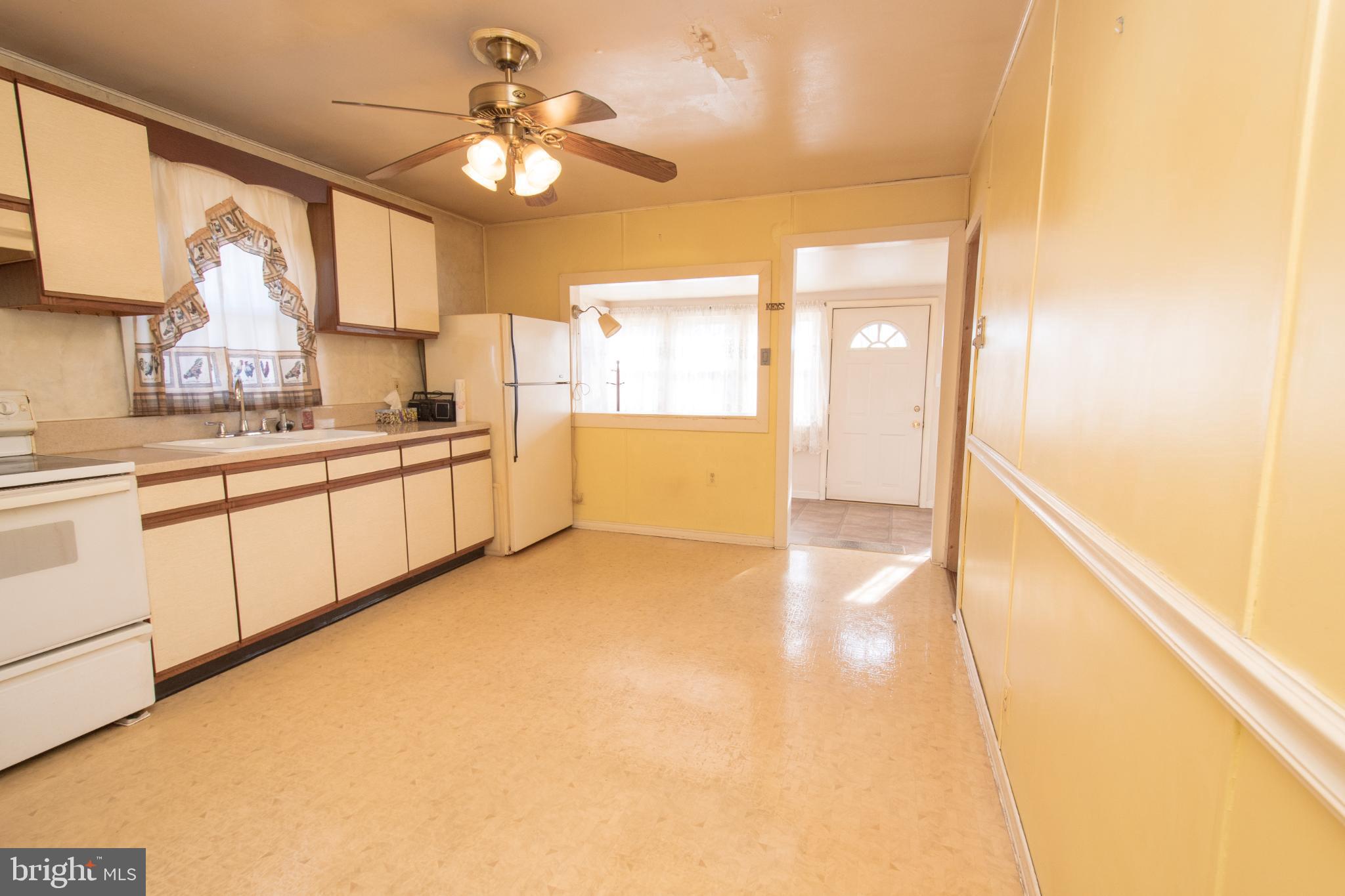 4022 West 7th Street Trainer, PA 19061 - Photo 15 of 49 a kitchen with a sink dishwasher a stove and white cabinets with wooden floor
