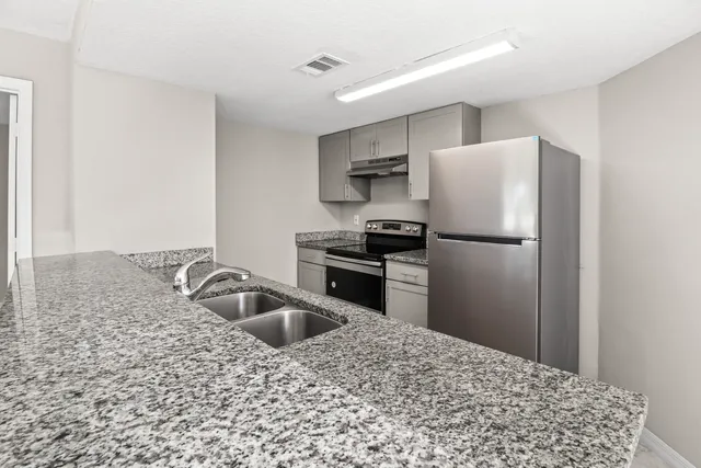 a kitchen with a stove a refrigerator and a sink