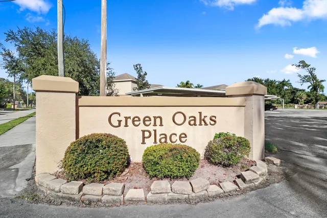 an aerial view of a house with swimming pool and large trees