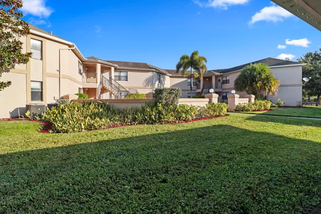 a front view of a house with a yard and potted plants