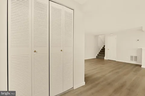 an empty room with wooden floor and closet