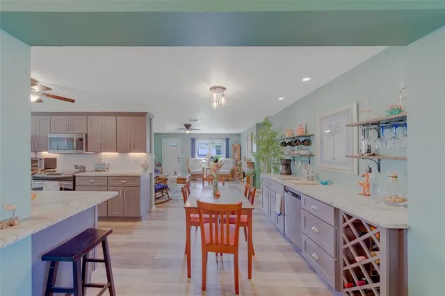 a kitchen with stainless steel appliances a sink a stove top oven a wooden floor and cabinets