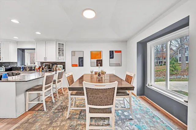 a kitchen with stainless steel appliances granite countertop a stove top oven a refrigerator a sink and dishwasher with wooden floor