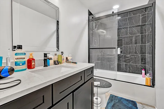 a bathroom with a sink a toilet a mirror and shower