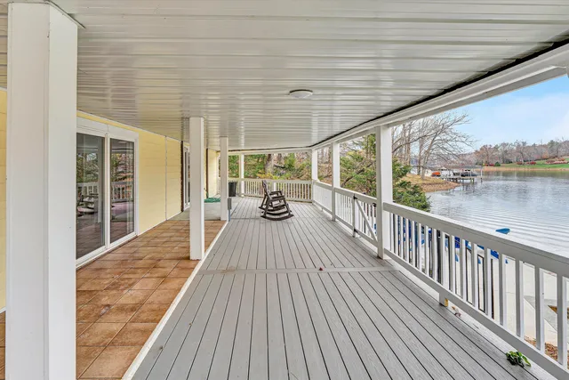 a view of a house with a small yard and wooden deck
