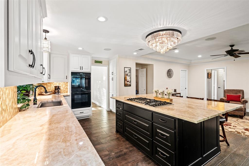 400 Hunters Ridge Circle Coppell, TX 75019 - Photo 7 of 35 a large kitchen with stainless steel appliances a stove a sink dishwasher and a dining table with wooden floor