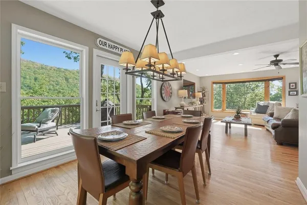 a dining room with wooden floor a chandelier a wooden table and chairs