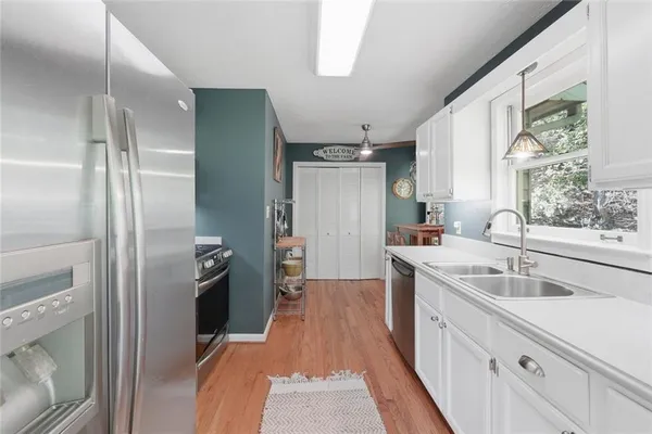 a kitchen with granite countertop a sink stove and refrigerator