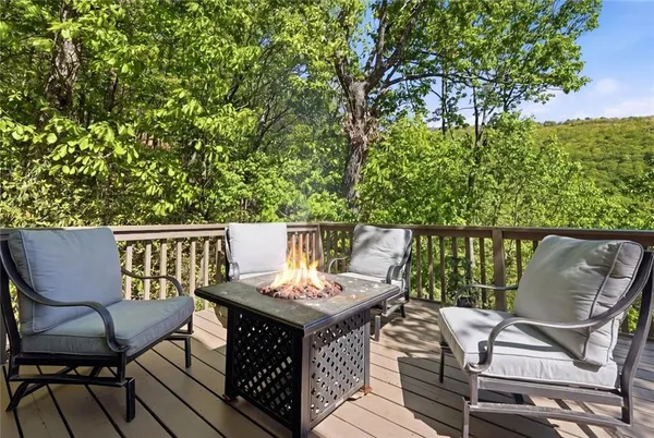 a balcony with wooden floor table and chairs