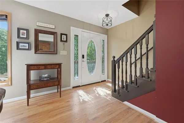 a view of an entryway with wooden floor and a fireplace