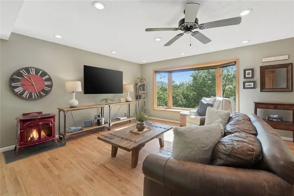 a living room with furniture a flat screen tv and a large window