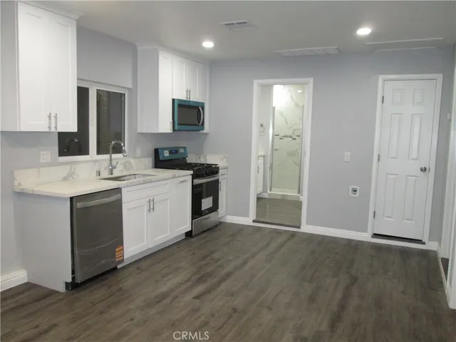 a kitchen with a sink cabinets and wooden floor