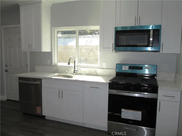a kitchen with stainless steel appliances a stove and a microwave
