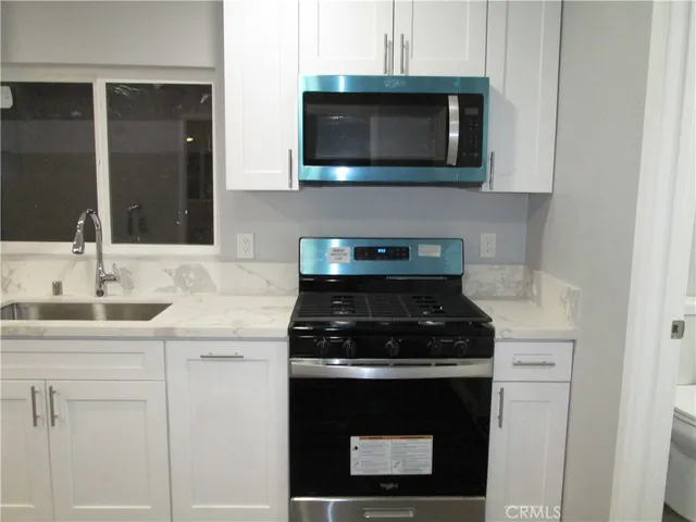 a kitchen with stainless steel appliances granite countertop white cabinets a stove top oven with dishwasher and granite countertops