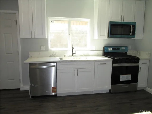 a kitchen with a sink stove and microwave