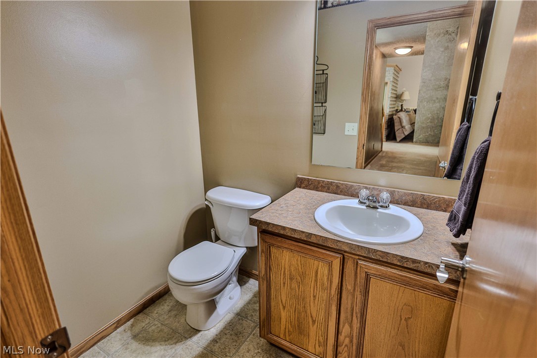 11154 Johnsford Road Southwest Beach City, OH 44608 - Photo 37 of 50 Bathroom vanity with an integrated white sink, laminate countertop, and wood-finish cabinetry