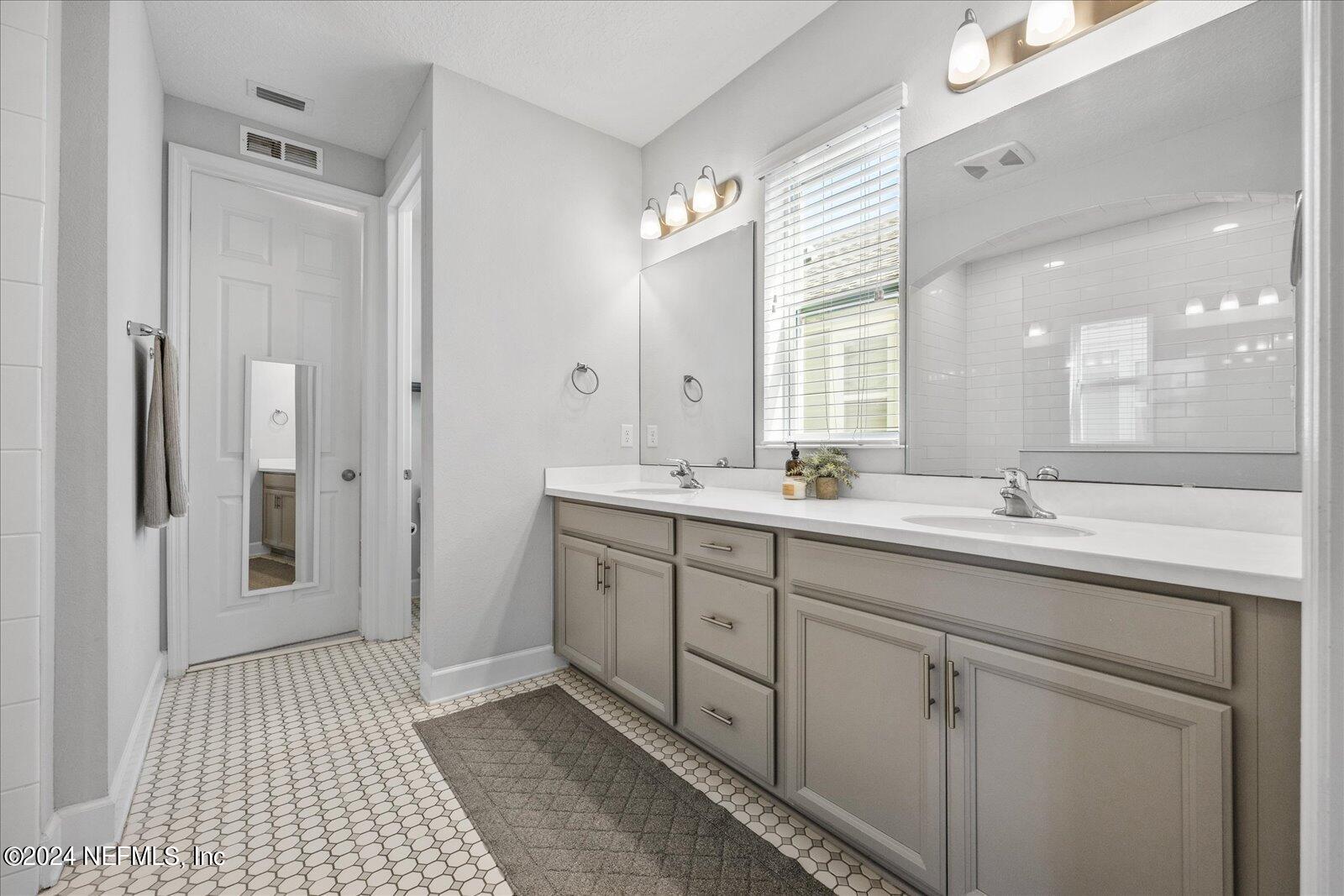 36 Foster Lane Ponte Vedra, FL 32081 - Photo 39 of 59 a bathroom with a double vanity sink a large mirror a shower and a bathtub