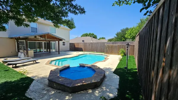 a view of a patio with swimming pool in front of it