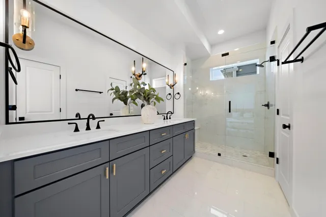 a bathroom with a double vanity sink mirror and shower