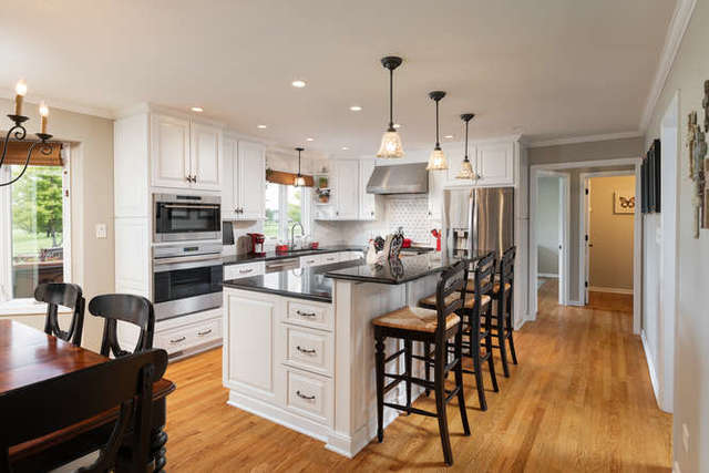 1572 White Eagle Drive Naperville, IL 60564 - Photo 7 of 33 a kitchen with stainless steel appliances kitchen island granite countertop a table chairs and a refrigerator