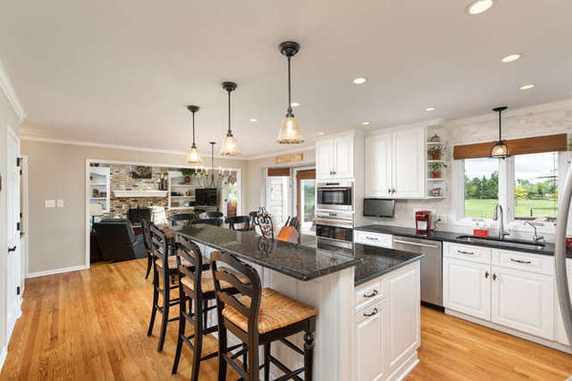1572 White Eagle Drive Naperville, IL 60564 - Photo 8 of 33 a kitchen with stainless steel appliances granite countertop a table chairs stove and white cabinets
