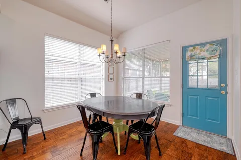a kitchen with a stove a sink and white cabinets with wooden floor