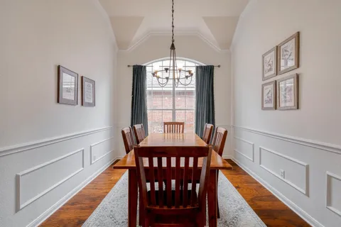 a dining room with furniture a chandelier and wooden floor