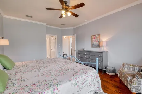 a bedroom with a bed a large window and a chandelier