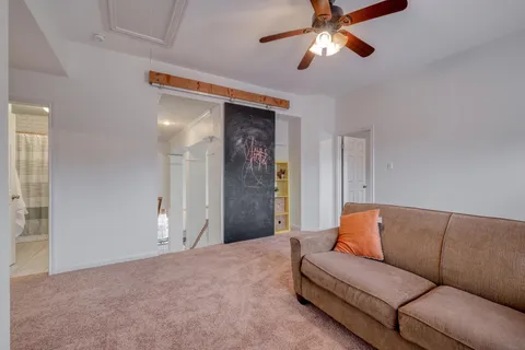 a living room with furniture and a ceiling fan