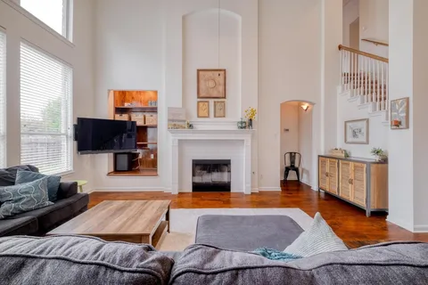 a living room with furniture a flat screen tv and a fireplace