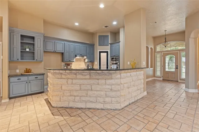 a kitchen with granite countertop a sink and cabinets