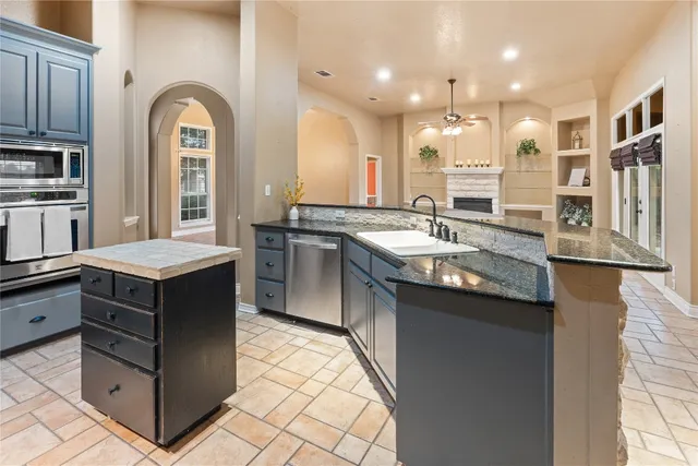 a large kitchen with stainless steel appliances granite countertop a large counter top and a stove