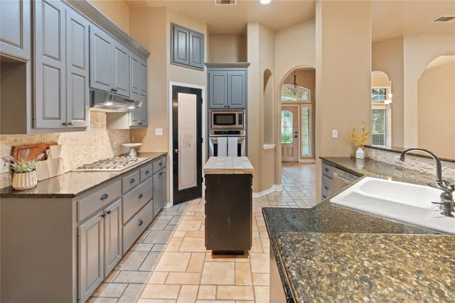 a bathroom with a granite countertop sink a mirror and a bathtub