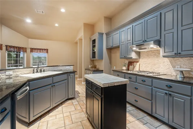 a kitchen with granite countertop a sink and cabinets