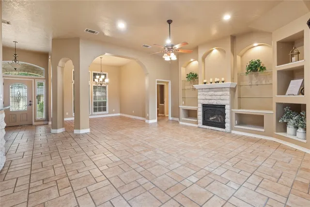 an empty room with fireplace and windows