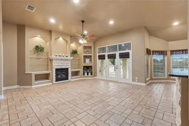 a view of an empty room with window and fireplace
