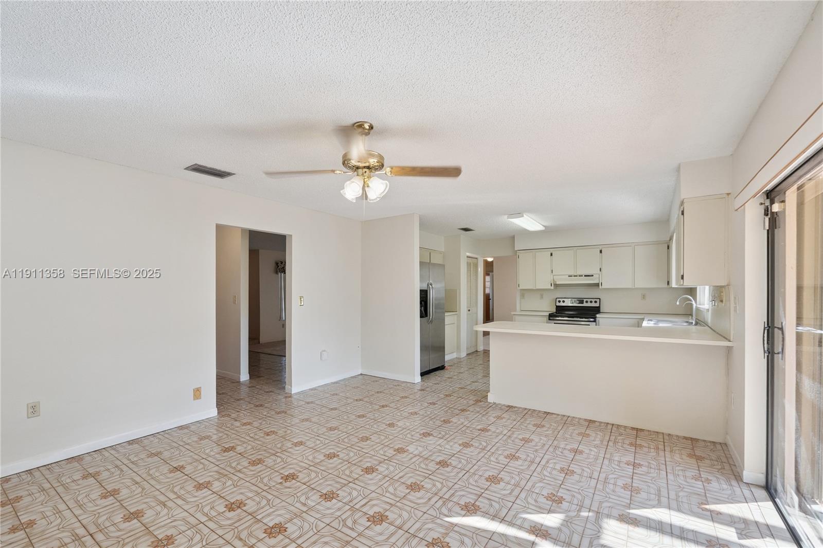9730 Southwest 5th Street Miami, FL 33174 - Photo 26 of 37 a view of a kitchen with kitchen island white cabinets and stainless steel appliances