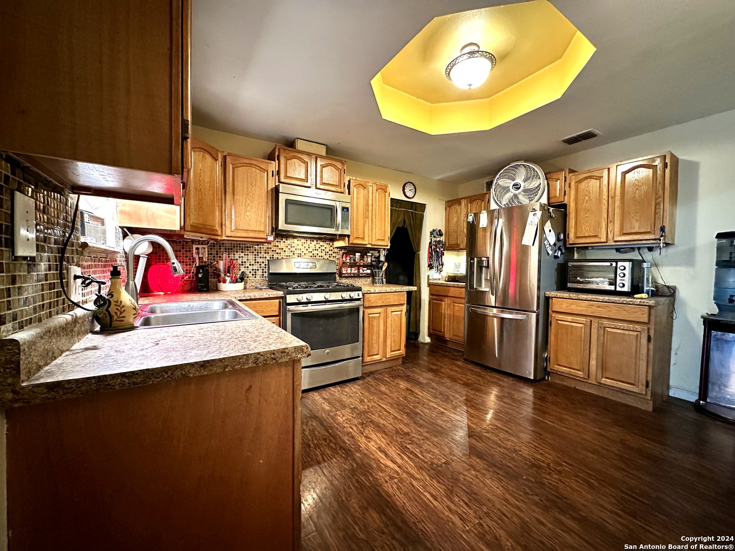 a kitchen with stainless steel appliances granite countertop a sink dishwasher stove and refrigerator