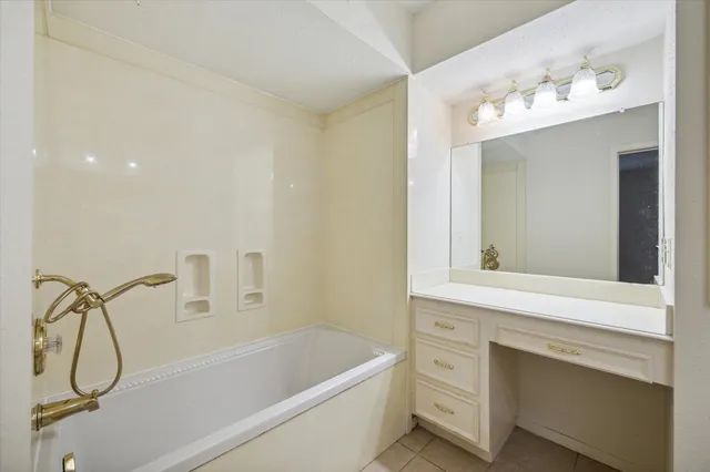 a bathroom with a sink vanity and bathtub