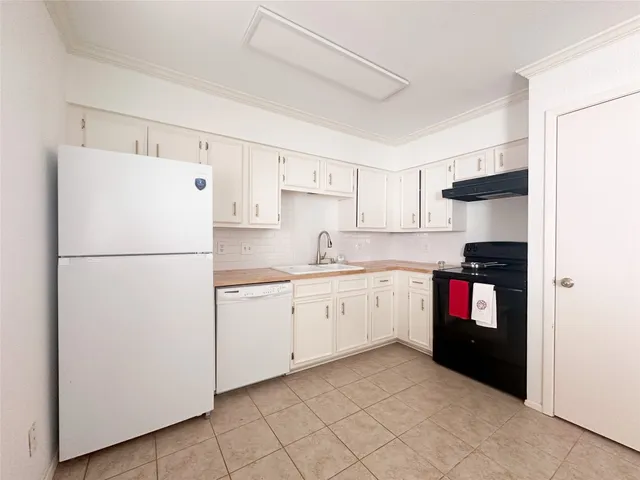 a kitchen with a refrigerator and a stove top oven