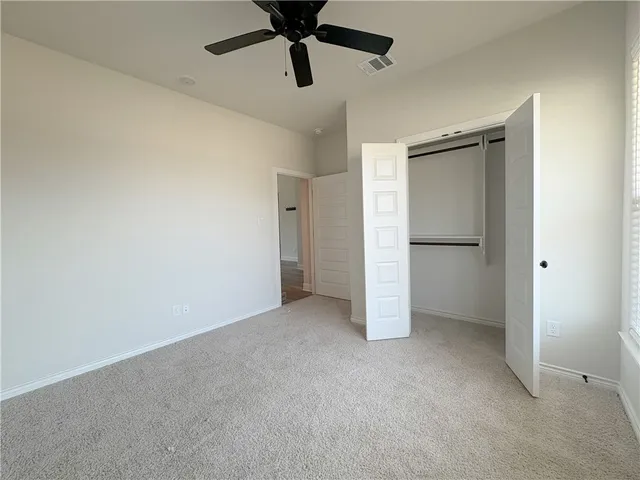a view of empty room with ceiling fan