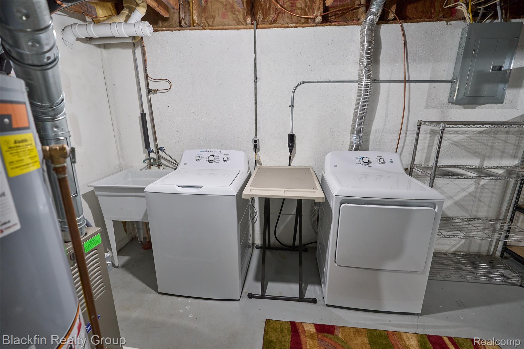 22625 Martin Road St. Clair Shores, MI 48081 - Photo 21 of 23 Laundry area with electric panel, finished concrete flooring, water heater, and independent washer and dryer