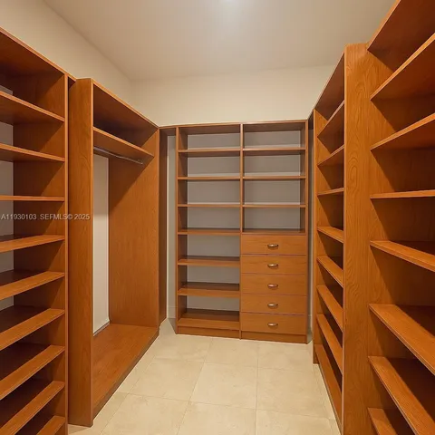 a view of walk in closet with empty racks