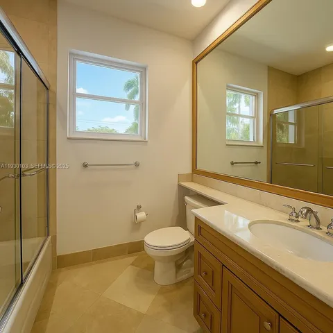 a bathroom with a granite countertop toilet a sink and mirror