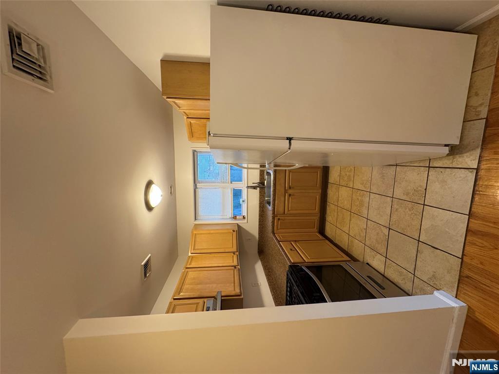 698 Undercliff Avenue Edgewater, NJ 07020 - Photo 2 of 10 a kitchen with a refrigerator sink and cabinets
