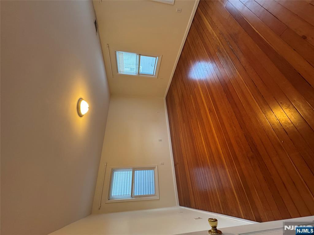 698 Undercliff Avenue Edgewater, NJ 07020 - Photo 7 of 10 a view of an empty room with wooden floor and a window
